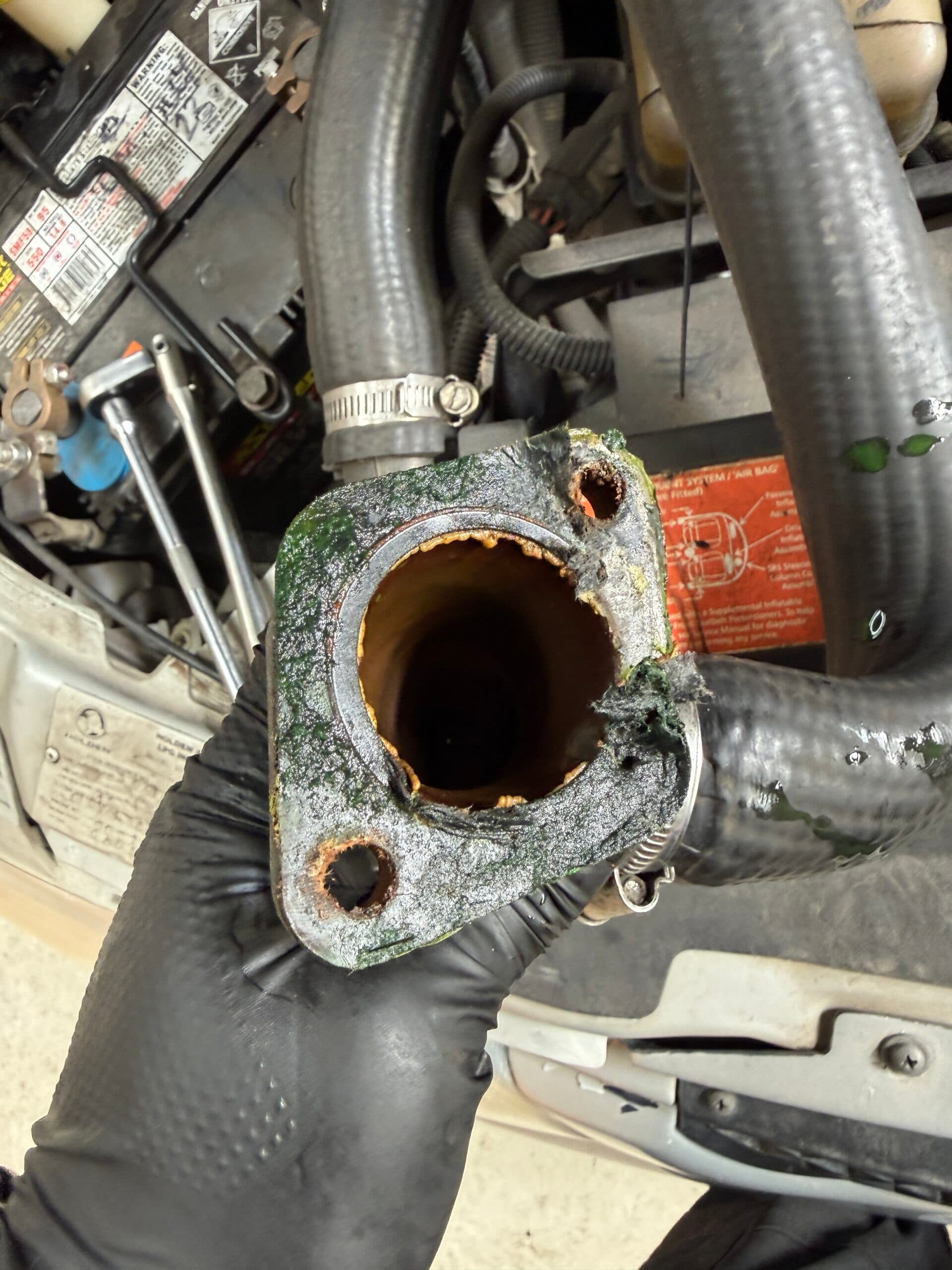 Old gasket residue on a removed Holden Commodore thermostat housing