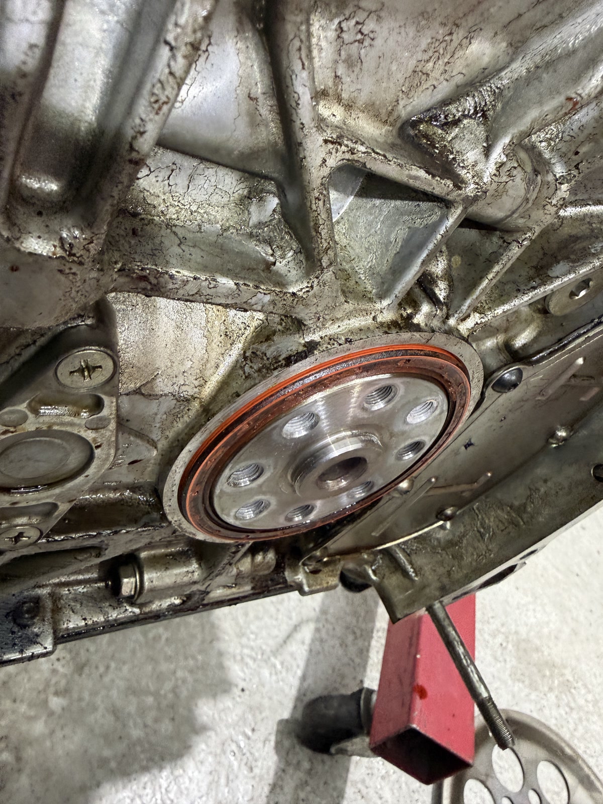 Subaru rear main seal area before replacement, with oil residue around the housing.